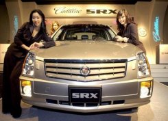 Unas modelos posan junto a un Cadillac SRX de General Motors el 12 de abril de 2004 en Seúl