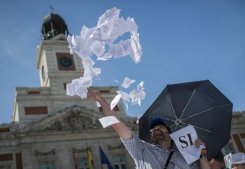 Un manifestante lanza papeletas durante una protesta contra los recortes del Gobierno, el 23 de junio en Madrid